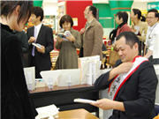 サインを求める列席者にとまどいながら応じる鈴木さん（秋田経済新聞）